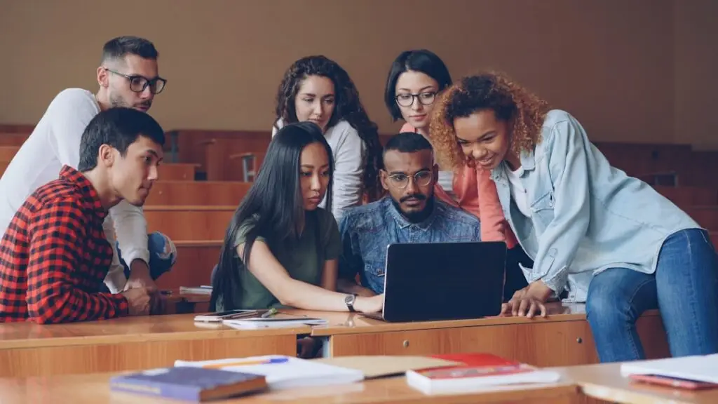 Students using a laptop together while studying with AI tools in 2026